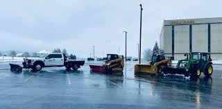 Snow removal equipment clearing a parking lot
